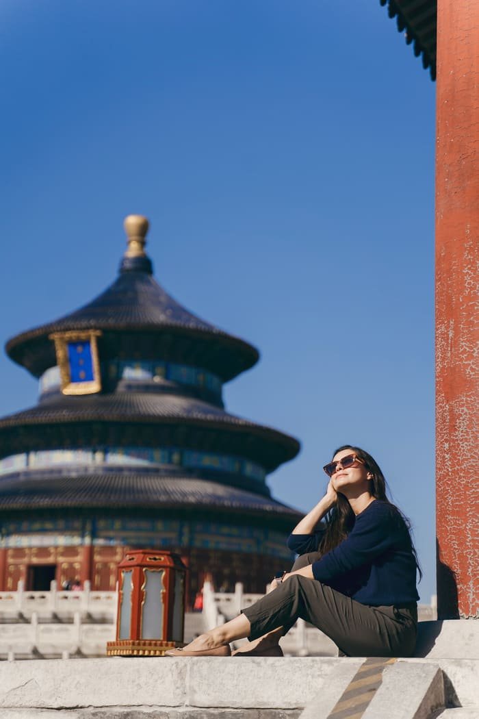 Una mujer sentada al fondo un templo chino