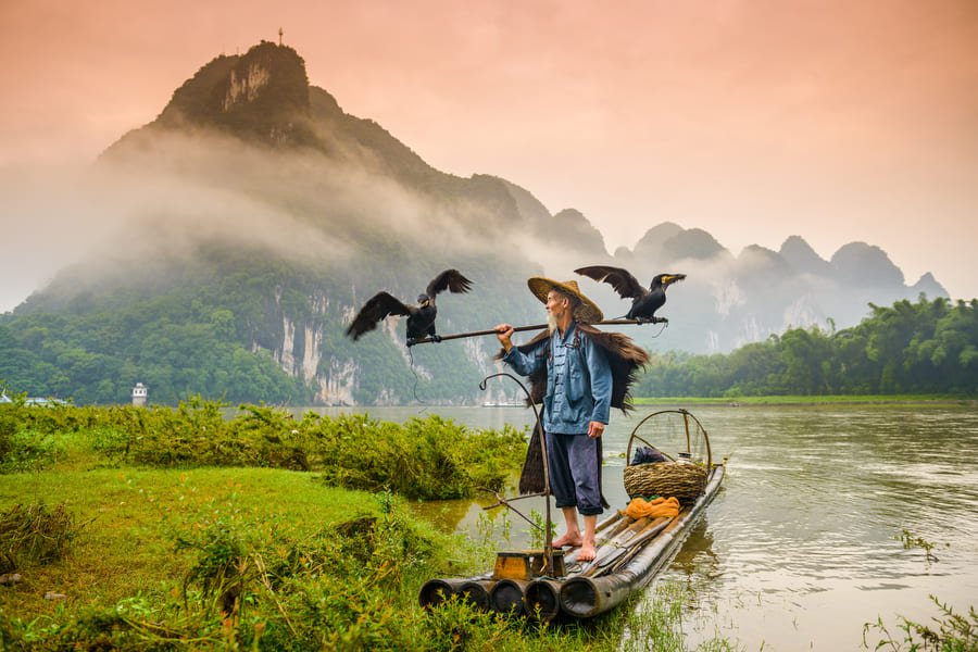 Un pescador en su lancha en la ciudad de Yangshuo
