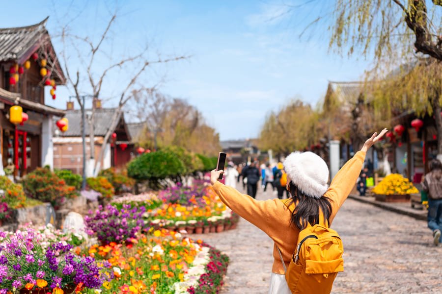 Una chica en la ciudad de Yunnan y unas casas de fondo